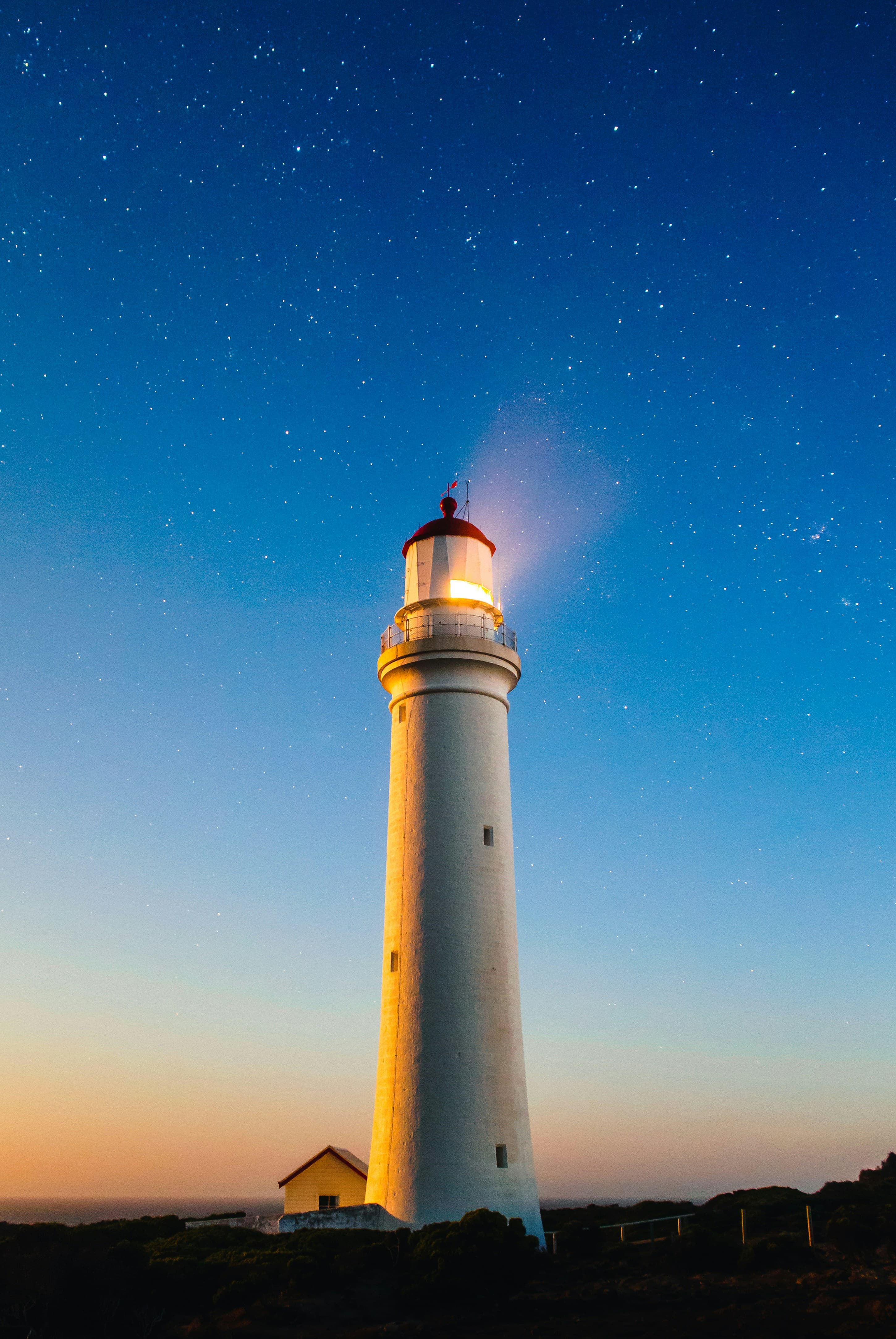 A lighthouse at dusk representing guidance for young creators